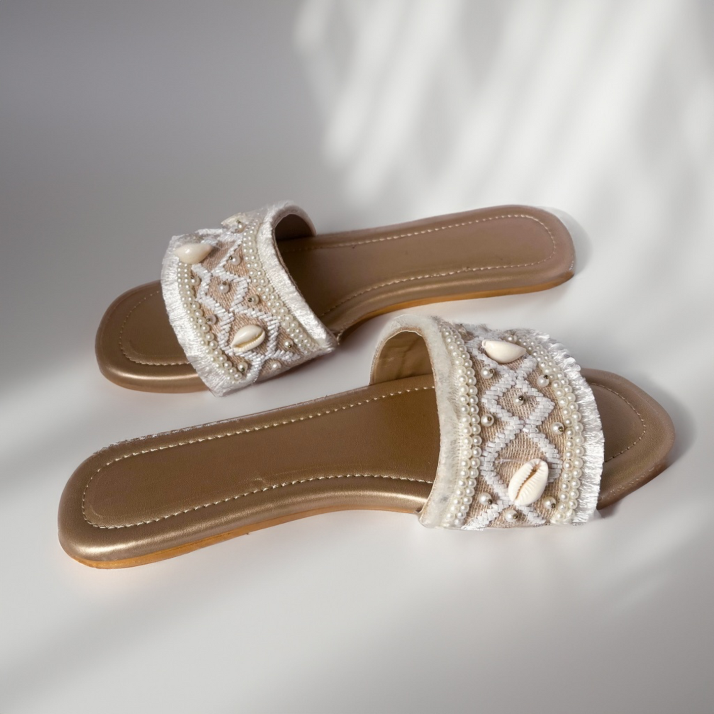 Pair of embellished sandals on a light background
