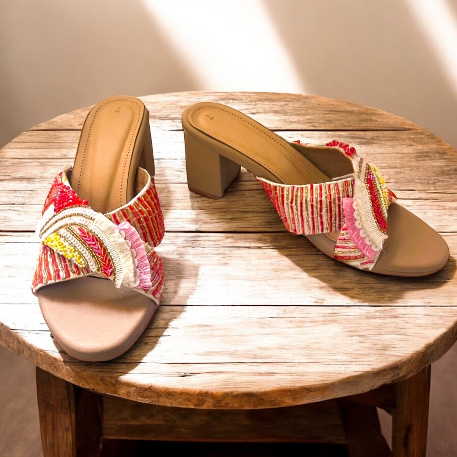 Pair of sandals with colorful straps on a wooden table