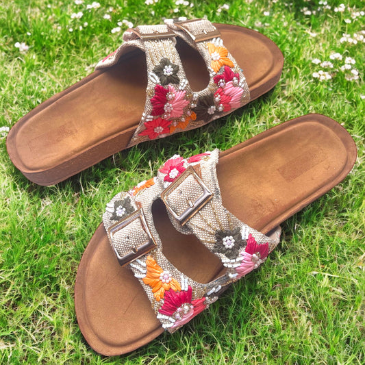 Pair of embellished sandals on a grassy background