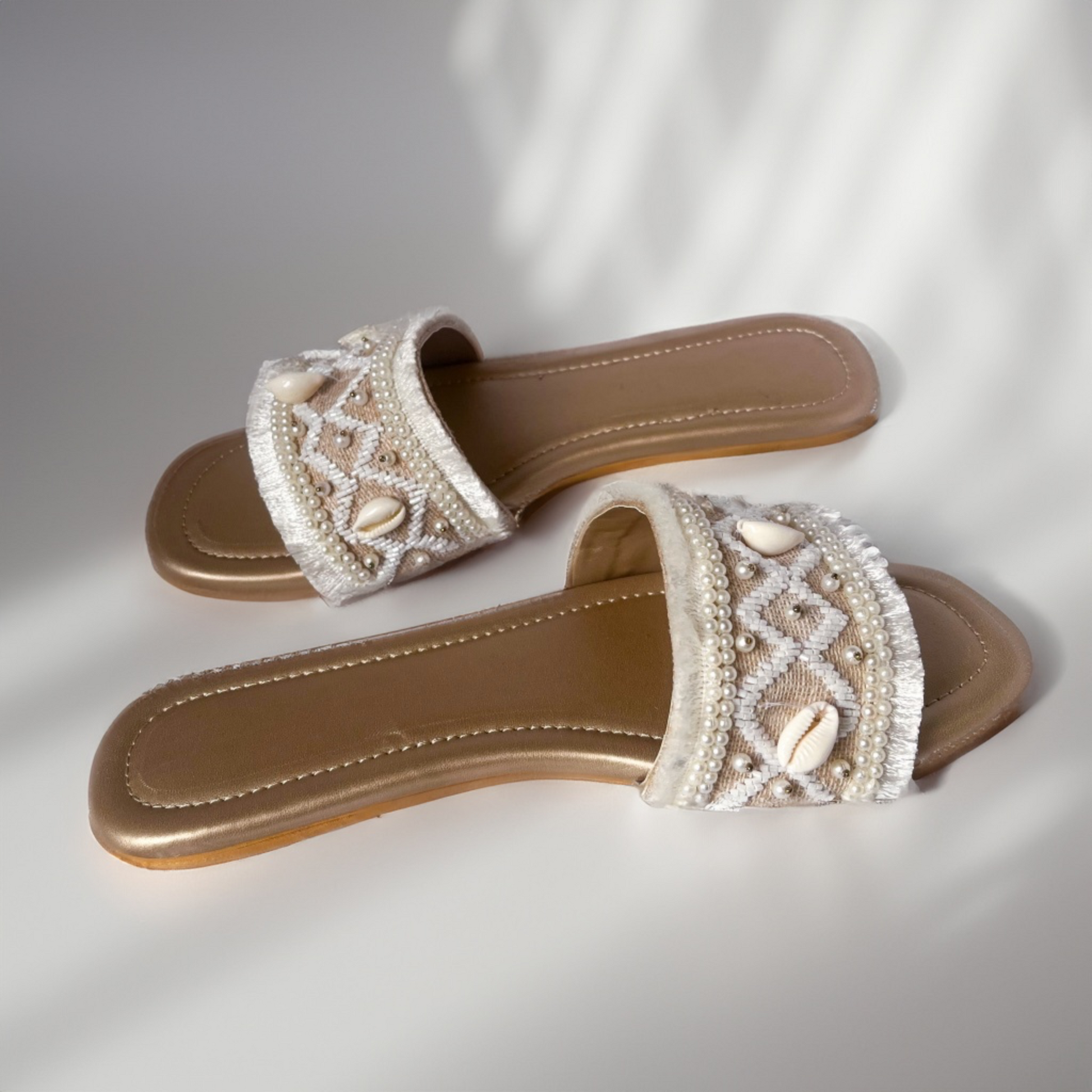 Pair of embellished sandals on a light background