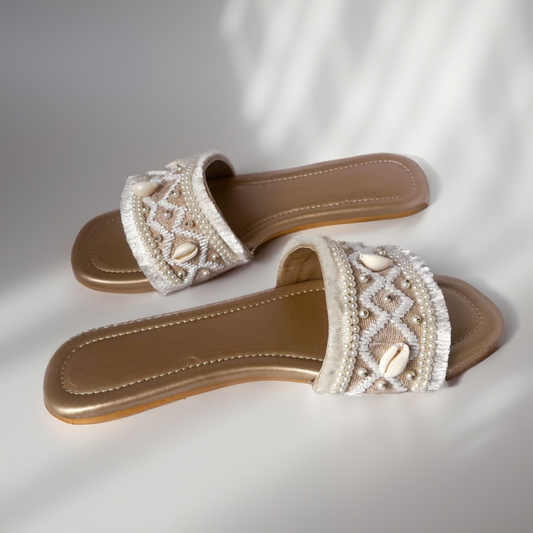 Pair of embellished sandals on a light background